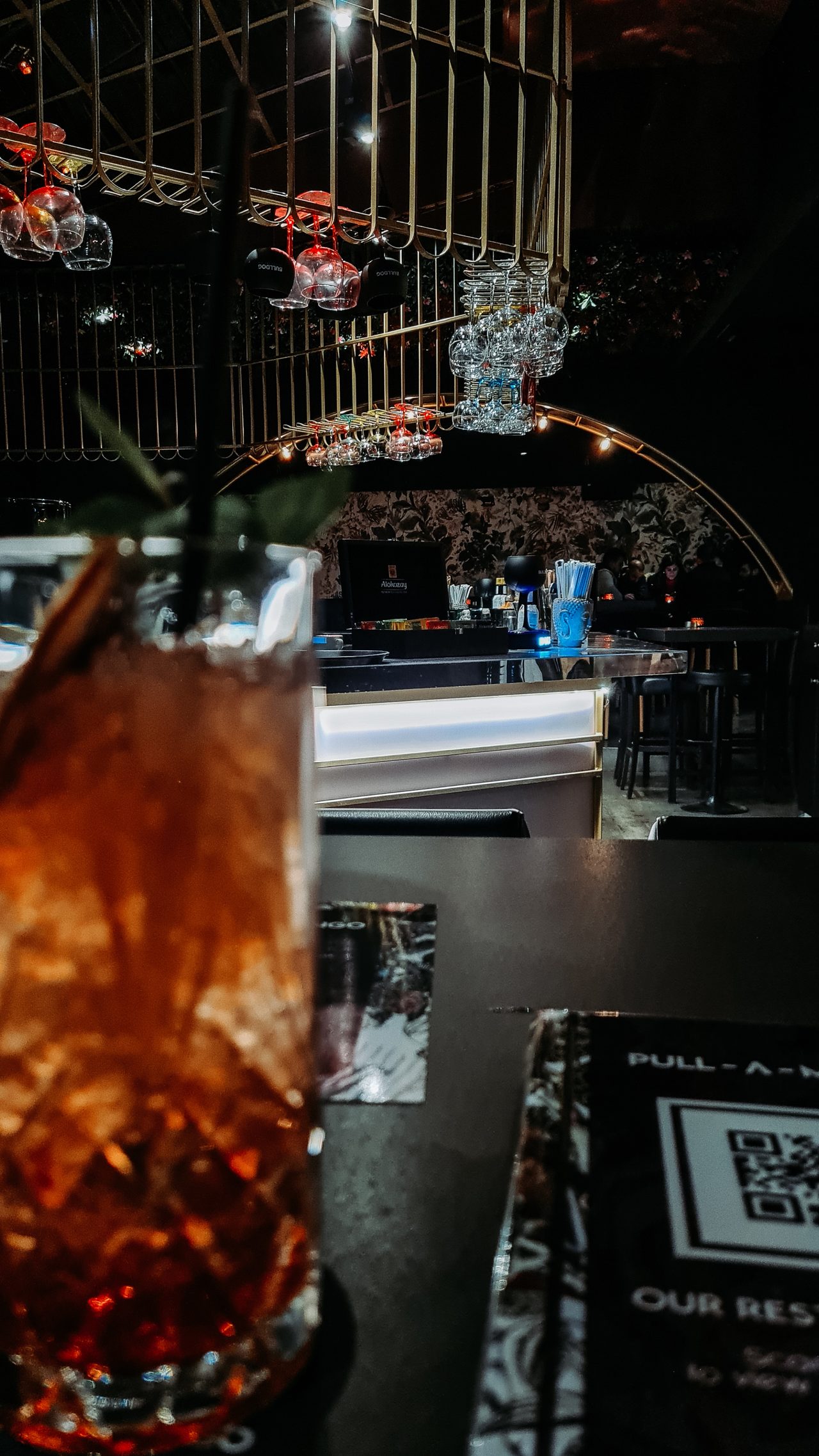 An amber cocktail in a dark, intimate bar