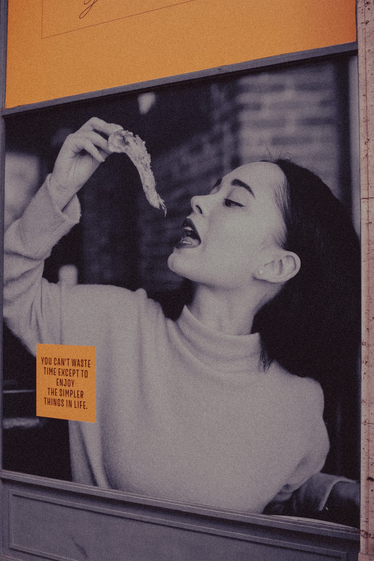 A street poster reading you can't waste time except to enjoy the simpler things in life