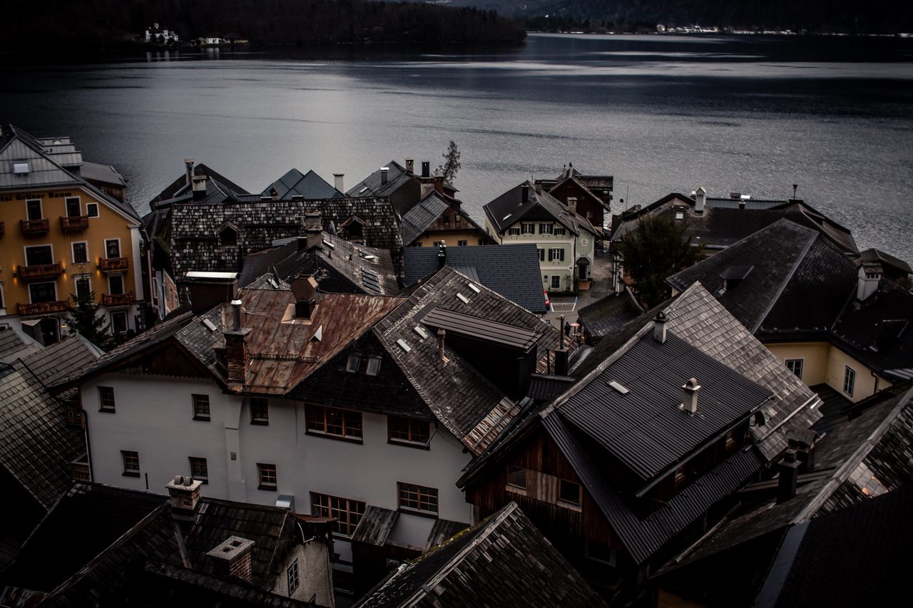 Dark alpine rooftops descending toward the still lake